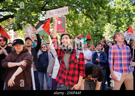 Des étudiants chantent des slogans pro-palestiniens et tiennent des drapeaux et des banderoles palestiniens lors de la première manifestation organisée en Pologne par des étudiants et des universitaires contre l'attaque israélienne sur la bande de Gaza devant le Collegium Novum, le bureau du doyen de l'Université Jagellonian à Cracovie, en Pologne, le 15 mai 2024. Banque D'Images