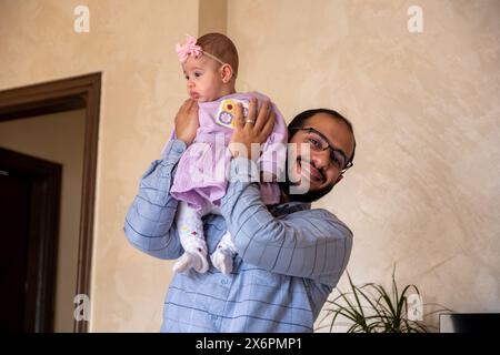 Père tenant le bébé nouveau-né souriant et regardant la caméra se sentant excité et amour Banque D'Images