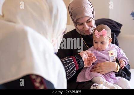 Mère et grand-mère jouent avec bébé portant de beaux vêtements célébrant et profitant de leurs moments avec les enfants Banque D'Images