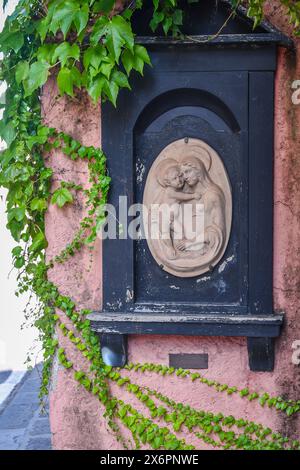 Un sanctuaire votif avec un bas-relief de la Vierge et de l'enfant à l'extérieur d'une vieille maison dans le village de pêcheurs de Portofino, Gênes, Ligurie, Italie Banque D'Images