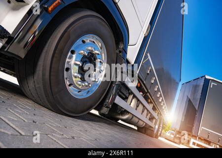 Vue détaillée d'un semi-camion stationné sur un terrain en briques. Banque D'Images