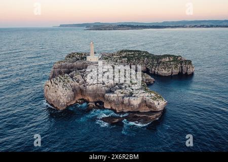 Un petit phare sur un rocher de pierre dans la mer près de la côte Banque D'Images