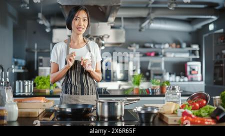 TV Cooking Show Kitchen : Chef asiatique parle des ingrédients, enseigne à cuisiner des aliments. Cours vidéo en ligne, service de streaming de cours vidéo e-Learning. Préparation de recette de plat traditionnel sain Banque D'Images