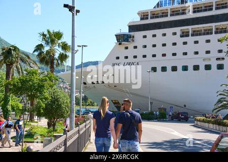 Kotor, Monténégro - 5 mai 2024 : jeune couple amoureux se promène le long de la promenade de Kotor au Monténégro et regarde le bateau de croisière MSC Lirica *** verliebtes Junges Paar läuft an der Promenade von Kotor au Monténégro entlang und blickt auf das Kreuzfahrtschiff MSC Lirica Banque D'Images