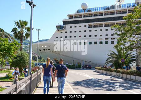 Kotor, Monténégro - 5 mai 2024 : jeune couple amoureux se promène le long de la promenade de Kotor au Monténégro et regarde le bateau de croisière MSC Lirica *** verliebtes Junges Paar läuft an der Promenade von Kotor au Monténégro entlang und blickt auf das Kreuzfahrtschiff MSC Lirica Banque D'Images