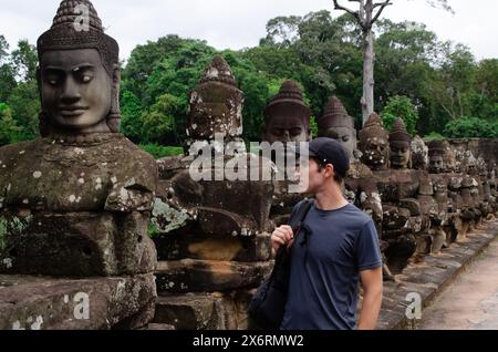 Touriste caucasien appréciant les sculptures en pierre d'Angkor Thom au Cambodge. Concept de voyage Banque D'Images