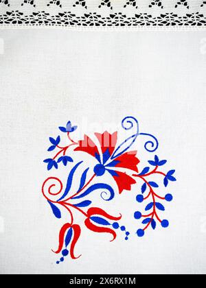 Ornement traditionnel slovène de broderie de nappe en bleu et rouge avec fleur d'oeillet Banque D'Images