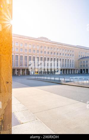 La lumière du soleil s'illumine au-dessus du terminal historique de l'aéroport Tempelhof à Berlin, projetant une lueur chaude sur sa façade. Banque D'Images