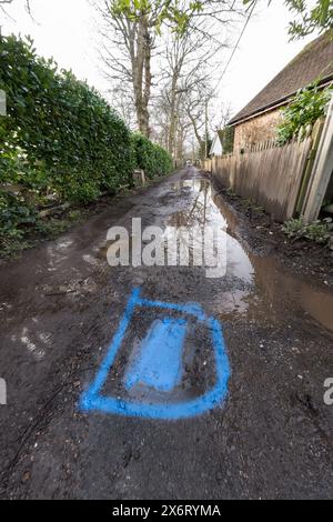 La peinture bleue en aérosol a finalement été utilisée pour identifier une fuite signalée dans l'eau principale seulement 4 semaines plus tard, détruisant la route non adoptée Banque D'Images