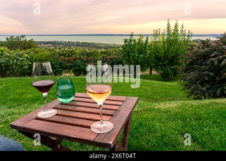 Table sur le lac Balaton avec des verres à vin sur la colline date romantique, pique-nique, manger sur la nature. Dégustation de vins de Csopak Banque D'Images