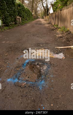 La peinture bleue en aérosol a finalement été utilisée pour identifier une fuite signalée dans l'eau principale seulement 4 semaines plus tard, détruisant la route non adoptée Banque D'Images