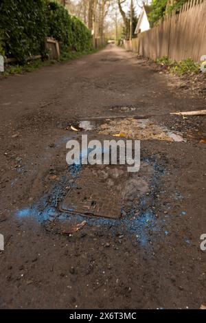 La peinture bleue en aérosol a finalement été utilisée pour identifier une fuite signalée dans l'eau principale seulement 4 semaines plus tard, détruisant la route non adoptée Banque D'Images