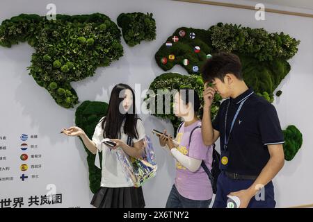 Wuhan, Chine. 16 mai 2024. Les visiteurs passent devant un mur avec une carte montrant les pays européens où les voitures VOYAH sont développées. L’administration Biden a annoncé mardi de nouveaux tarifs pour les véhicules électriques de fabrication chinoise, quadruplant le tarif actuel de 27,5% à 102,5%, ainsi que de nouveaux tarifs sur les cellules solaires, l’acier et l’aluminium. Crédit : SOPA images Limited/Alamy Live News Banque D'Images