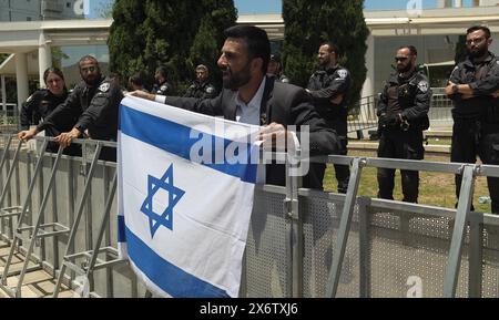 La police veille alors que Yoosen Haddad, un influenceur des médias sociaux arabo-israélien et militant pour Israël, tient le drapeau israélien et crie contre les étudiants arabes et juifs israéliens participant à une cérémonie commémorant la Journée palestinienne de la Nakba ('catastrophe') à l'université de tel Aviv le 15 mai 2024 à tel Aviv, Israël. La Journée de la Nakba est une journée annuelle de commémoration du déplacement des Palestiniens qui a précédé et suivi la Déclaration d'indépendance israélienne en 1948. Banque D'Images