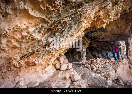 Touriste à sa Cova des Voltor, (la grotte des vautours), carrière historique de grès, Petra, Majorque, îles Baléares, Espagne. Banque D'Images