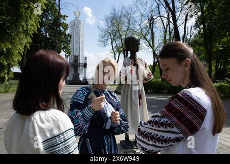 Kiev, Ukraine. 16 mai 2024. Des femmes vêtues de vyshyvankas (un vêtement traditionnel slave qui contient des éléments de broderie ethnique ukrainienne) parlent près du monument de la « mémoire amère de l'enfance » qui symbolise les victimes de l'Holodomor (famine) vêtues des mêmes vêtements à l'occasion de la Journée Vyshyvanka à Kiev. (Photo de Oleksii Chumachenko/SOPA image/SIPA USA) crédit : SIPA USA/Alamy Live News Banque D'Images