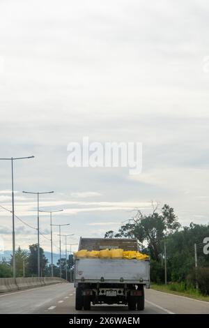 camion à benne basculante sur la route de montagne transportant des marchandises sur la route droite. vue arrière de la voiture. Banque D'Images