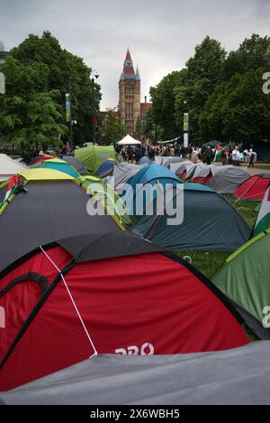 Manchester, Greater Manchester, Royaume-Uni. 15 mai 2024. Les manifestants arrivent au loin, de nombreuses tentes ont été dressées dans le camp de résistance sur les pelouses de l'Université de Manchester. Les manifestants descendent dans les rues de Manchester pour commémorer le 76e anniversaire de la Nakba (la catastrophe) lorsqu’en 1948, plus de 700 000 Palestiniens ont fui ou ont été expulsés de leurs maisons et de leurs terres par les paramilitaires et l’État israélien. Cette population et ses décents vivent en exil et promettent de revenir un jour. Ils terminent le rallye à l'Université de Manchester où les étudiants et leurs Banque D'Images