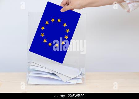 Élection européenne, électrice manuelle féminine avec bulletin de vote, urne transparente, partis politiques, droit de vote, devoir civique, participation citoyenne Banque D'Images