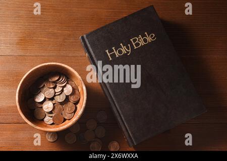 Donnez et donnez concept. Pièces de monnaie dans le bol et la Bible sur la table en bois, plat Banque D'Images