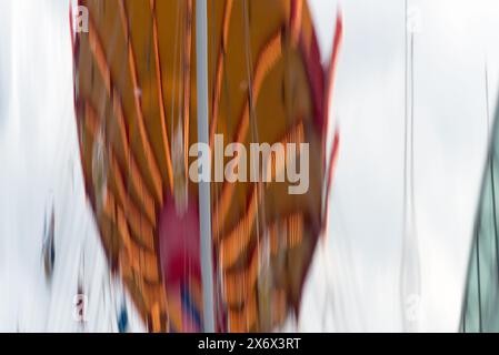 Une image floue d'une montgolfière avec un motif rouge et jaune. Le ballon est suspendu dans les airs et il se déplace Banque D'Images