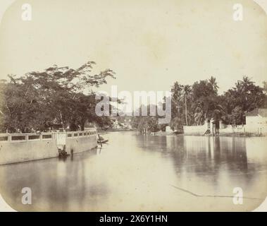 Le Kali Mas, le Kali Mas à Surabaya avec un haut mur et des arbres à gauche, une maison au milieu au loin et aussi une maison à droite. Un seul canoë est amarré au loin. Une partie de l'album photo présenté par l'Association Soerabayasche des fabricants de sucre à Frederik Beyerinck, résident de Soerabaya., photographie, Herman Salzwedel, Soerabayasche Vereeniging van Suikerfabrikanten, Surabaya, 1876 - 1884, support photographique, tirage à l'albumine, hauteur, 22 cm × largeur, 27,5 cm Banque D'Images