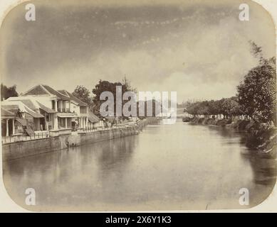 Le Kali Mas, le Kali Mas près de Genteng à Surabaya avec un haut mur de quai avec des maisons sur la gauche. Un certain nombre d'échelles pendent dans l'eau depuis le quai. A droite de la rivière, le quai est envahi par la végétation et il y a des arbres. Une partie de l'album photo présenté par l'Association Soerabayasche des fabricants de sucre à Frederik Beyerinck, résident de Soerabaya., photographie, Herman Salzwedel, Soerabayasche Vereeniging van Suikerfabrikanten, Surabaya, 1876 - 1884, support photographique, tirage à l'albumine, hauteur, 21,1 cm × largeur, 27,3 cm Banque D'Images
