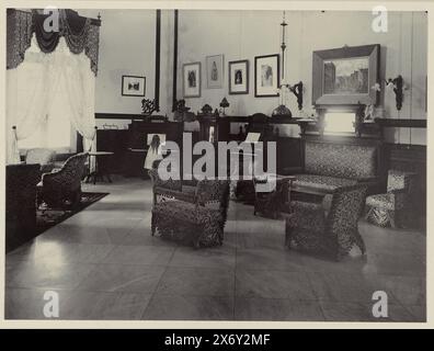 Chambre avec fauteuils, Chambre avec fauteuils et piano, dans la maison de Sam van Musschenbroek. Avec la fille de Sam van Musschenbroek debout derrière le piano. Page d'album séparée dans l'album photo sur la sucrerie Tjomal (Comal) sur Java dans la période 1890-1910., photographie, Otto Hisgen, (mentionné sur l'objet), Comal, 1890 - 1910, support photographique, hauteur c. 230 mm × largeur c. 170 mm Banque D'Images