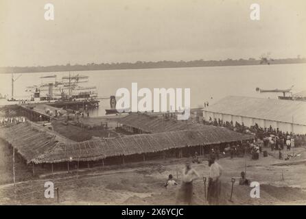 Port avec des bâtiments en chaume, jetée, navires et public au Cameroun, partie de l'album photo avec des enregistrements du Cameroun vers 1899., photographie, anonyme, Kameroen, 1899, support photographique, tirage albumine, hauteur, 131 mm × largeur, 196 mm Banque D'Images