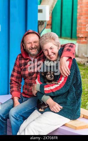 Couple marié russe mature embrassant et tenant un chien Banque D'Images