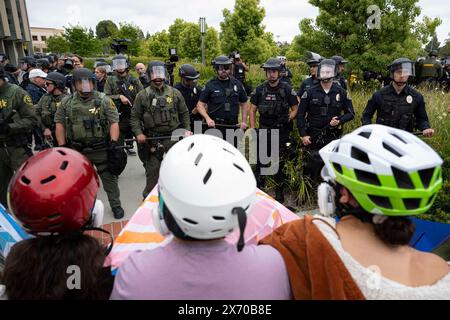 Irvine, Californie, États-Unis. 1er janvier 2023. Les manifestants peuvent être vus debout les pieds loin des officiers de Swim alors qu'ils attendent l'inévitable avance des policiers. Des agents de nombreux services de police autour du comté d'Orange, en Californie, ont été appelés sur le campus d'Irvine de l'Université de Californie (UC) pour nettoyer un campement palestinien en pleine expansion prenant le contrôle du centre de l'Université. Les étudiants se barricadèrent en cercle, fortifiant leur périmètre avec des palettes de bois et divers autres objets pour empêcher les autorités d'entrer. Au total, 50 manifestants ont été arrêtés dans le campement Banque D'Images