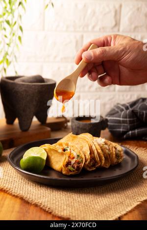 Suadero Tacos. Viande hachée frite dans une mini tortilla de maïs. Cuisine de rue de CDMX, Mexique, traditionnellement accompagnée de coriandre, d'oignon et de rouge épicé Banque D'Images