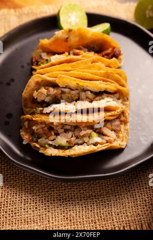 Suadero Tacos. Viande hachée frite dans une mini tortilla de maïs. Cuisine de rue de CDMX, Mexique, traditionnellement accompagnée de coriandre, d'oignon et de rouge épicé Banque D'Images