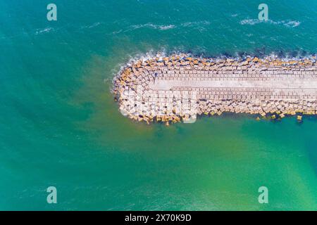 Vue zénithale aérienne d'un groyne sur une plage, brise-lames pour la protection du port Banque D'Images