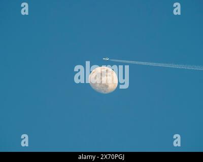 Avion de passagers L'avion passe près de la lune. Explorez une nouvelle frontière. Voyageur spatial avion conceptJet avec traînée de carburant dans le ciel bleu sur la pleine lune arrière Banque D'Images