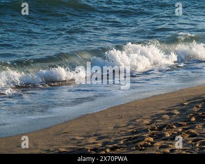 De belles vagues d'eau courbes sont utilisées comme image de fond. Vague océanique. Spectaculaire photo de fond aérienne supérieure de la vague blanche de l'eau de mer de l'océan spla Banque D'Images