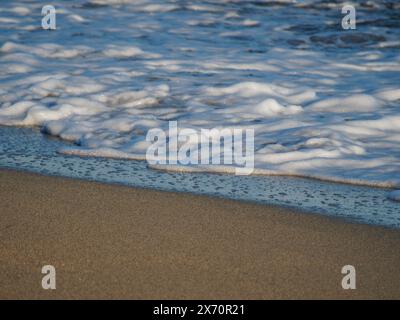 De belles vagues d'eau courbes sont utilisées comme image de fond. Vague océanique. Spectaculaire photo de fond aérienne supérieure de la vague blanche de l'eau de mer de l'océan spla Banque D'Images