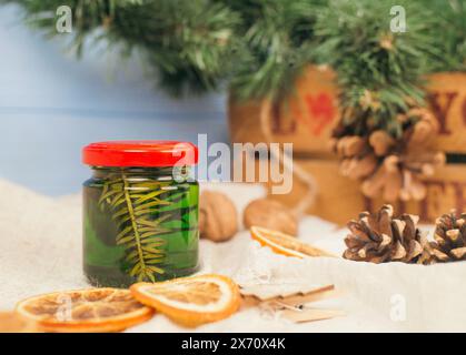 Miel vert avec des aiguilles de pin dans un bocal en verre. Pot en verre avec du miel sur un fond d'atmosphère de noël. Recettes nationales. Banque D'Images