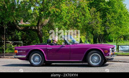 Stoke Goldington, Royaume-Uni - 11 mai 2024 : 1973 Purple Triumph TR6 voiture classique conduisant sur une route britannique Banque D'Images