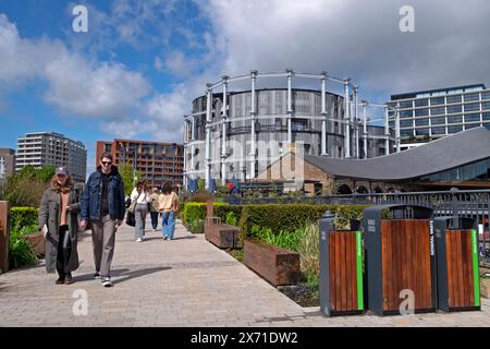 Les gens marchant près des immeubles d'appartements de luxe Gasholder et Coal Drops Yard dans la région de Kings Cross à Londres Angleterre Royaume-Uni Grande-Bretagne KATHY DEWITT Banque D'Images