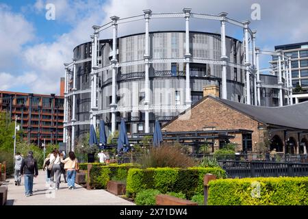 Les gens marchant près des immeubles d'appartements de luxe Gasholder et Coal Drops Yard dans la région de Kings Cross à Londres Angleterre Royaume-Uni Grande-Bretagne KATHY DEWITT Banque D'Images