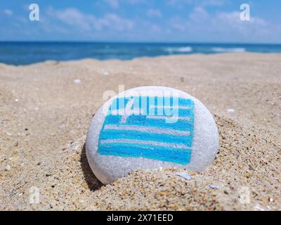 Grèce drapeau de pays peint sur la pierre de mer sur la plage de sable vide avec vue sur la mer de près. Concept de vacances. Banque D'Images