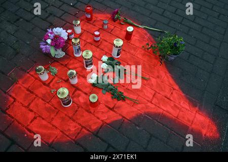 Duesseldorf, Allemagne. 17 mai 2024. Bougies et fleurs gisent dans un cœur rouge pulvérisé sur le trottoir. Suite à l’explosion et à l’incendie dévastateur d’un immeuble résidentiel et commercial à Düsseldorf qui a fait trois morts, la police poursuit son enquête vendredi. L'accent reste mis sur la cause encore peu claire de l'explosion et de l'incendie qui a suivi. Crédit : Federico Gambarini/dpa/Alamy Live News Banque D'Images