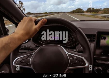 Vue du conducteur sur le compteur de vitesse à 119 km/h, sur une route floue. Vue du jour de l'intérieur d'une voiture de conducteur POV du paysage routier. Banque D'Images