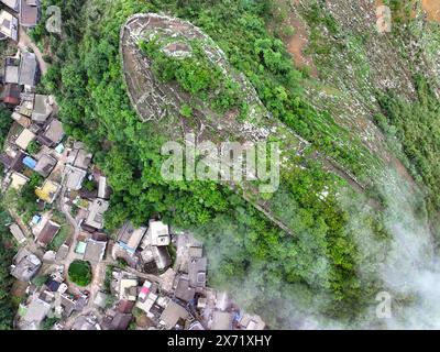 Qianxinan. 17 mai 2024. Une photo prise par un drone aérien le 17 mai 2024 montre une vue des ruines d'une ancienne ville datant de la dynastie Ming (1368-1644) au village de Pingzhai de la préfecture autonome de Bouyei-Miao de Qianxinan, dans la province du Guizhou au sud-ouest de la Chine. Le site apparaît de forme ovale vu d'en haut, couvrant une superficie d'environ 18 000 mètres carrés, avec plus de 900 mètres de murs de pierre restés. Crédit : Liu Xu/Xinhua/Alamy Live News Banque D'Images