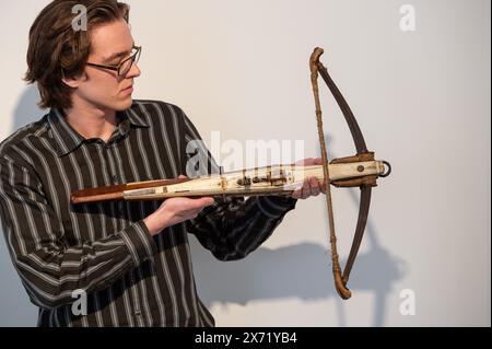 Londres, Angleterre, Royaume-Uni. 17 mai 2024. Le membre du personnel de Bonhams tient une arbalète sportive allemande, fin du XVIe siècle, estimée à Â£800 - Â£1 200, lors d'une avant-première de vente d'armes et armures antiques à Bonhams Knightsbridge. (Crédit image : © Thomas Krych/ZUMA Press Wire) USAGE ÉDITORIAL SEULEMENT! Non destiné à UN USAGE commercial ! Banque D'Images