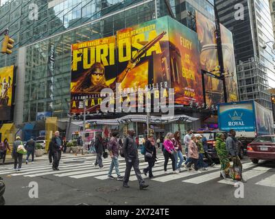 Des hordes de gens traversent West 42nd Street sous la publicité pour les Warner Bros “Furiosa A Mad Max Saga”, un autre film de la franchise Mad Max, le dimanche 12 mai 2024. La sortie du film est prévue pour le 24 mai. (© Richard B. Levine) Banque D'Images