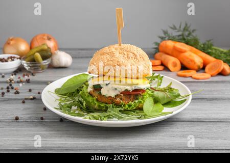 Délicieux burger végétarien servi sur une table en bois gris Banque D'Images