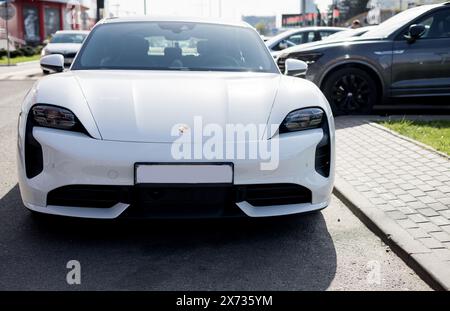 Minsk, Biélorussie, 17 mai 2024 - vue de face voiture électrique Porsche Taycan blanche Banque D'Images