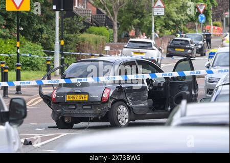 Clevedon Road, Birmingham, 17 mai 2024 - la police des West Midlands a fermé plusieurs routes dans la région de Balsall Heath à Birmingham après une poursuite policière qui a conduit le conducteur en fuite d'une Nissan Micra à s'écraser sur un autre véhicule. Un occupant masculin du Micra a été grièvement blessé et emmené à l'hôpital en état d'arrestation. Deux autres hommes ont fui la scène, l'un a été arrêté peu de temps après et l'autre est exceptionnel. Les officiers ont inondé le secteur de Clevedon Road et Lincoln Street en mettant en place un grand cordon. Un entraîneur pour homme et une veste noire ainsi que les premiers soins pouvaient être vus sur la route à une croix piétonne Banque D'Images